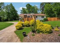 Charming home featuring a spacious front yard, beautiful landscaping, and inviting deck, perfect for relaxing outdoors at 1932 Brenda Dr, Austell, GA 30168