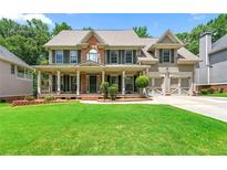 Charming two-story home with a well-manicured lawn, covered porch, and attached two-car garage at 5652 Harbormist Dr, Powder Springs, GA 30127