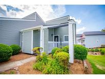 Charming home with muted-green siding, manicured shrubbery, and inviting covered porch at 325 Berry Ct, Villa Rica, GA 30180