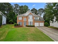 Traditional brick home with two-car garage and manicured lawn at 4325 Camellia Ridge Sw Way, Lilburn, GA 30047