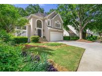 Charming two-story home with manicured lawn, driveway, two car garage, and traditional architectural details at 5065 Harbour Ridge Dr, Alpharetta, GA 30005
