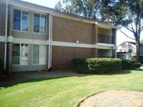 A brick apartment building with large windows and well-maintained landscaping with a lawn at 3301 Henderson Mill Rd # J1, Atlanta, GA 30341