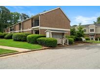 Two-story brick apartment building with manicured lawn and mature landscaping at 3301 Henderson Mill Rd # J1, Atlanta, GA 30341
