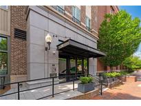 Inviting entrance featuring a covered walkway, brick accents, and manicured landscaping at 58 Canton St # 404, Alpharetta, GA 30009