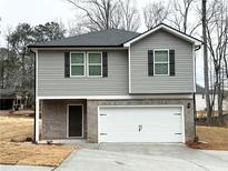 Two-story home featuring gray siding, brick accents, and an attached two-car garage at 131 Deer Xing, Temple, GA 30179