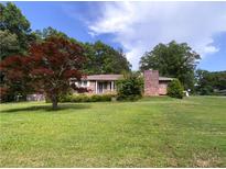 Quaint single-story brick home with a neatly maintained lawn and mature landscaping at 4179 Westview St, Douglasville, GA 30135
