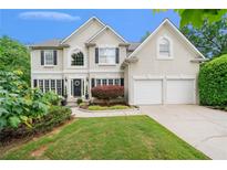 Charming two-story home with a manicured front yard, black shutters, and a two car garage at 1360 Woodvine Way, Alpharetta, GA 30005