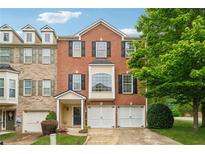 Charming brick townhome featuring a two-car garage and well-maintained landscaping at 200 Valley Xing, Canton, GA 30114