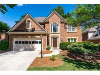 Charming two-story brick home featuring an attached garage and manicured landscaping at 4648 Glenshire Pl, Atlanta, GA 30338