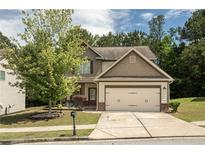 Charming two-story home featuring a two-car garage and a well-manicured front yard with mature landscaping at 856 Donington Cir, Lawrenceville, GA 30045