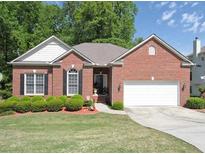 Charming single-story brick home featuring a two-car garage and well-manicured lawn with lush landscaping at 361 Brackin Trce, Grayson, GA 30017