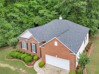 Aerial view of a brick home featuring an attached two-car garage and well-maintained landscaping at 361 Brackin Trce, Grayson, GA 30017