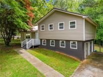 Charming two-story home with tan siding and well-maintained landscaping at 115 S Meadowcliff Cir, Carrollton, GA 30116
