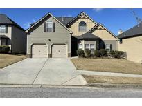 Charming two-story home featuring a two-car garage and well-manicured lawn at 1291 Long Acre Dr, Loganville, GA 30052