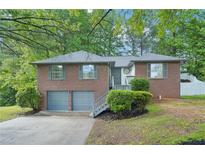 Charming brick home with a two-car garage, landscaped front yard, and inviting entrance at 4787 Burford Nw Ct, Acworth, GA 30102