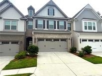 Modern townhome featuring a two-car garage, beautiful brick, and inviting curb appeal at 2059 Lanier Harbor Pt, Buford, GA 30518