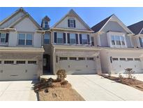 Charming townhome featuring brick accents, a two-car garage, and manicured landscaping at 2059 Lanier Harbor Pt, Buford, GA 30518