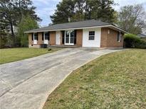 Quaint brick home featuring a long driveway and a well-maintained front yard at 6927 Eunice Dr, Riverdale, GA 30274