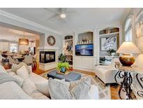 Inviting living room featuring a fireplace, hardwood floors, and built-in shelving at 7435 Jamestown Dr, Alpharetta, GA 30005