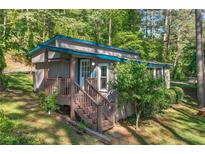 Charming exterior view of home with a cozy front porch and natural, wooded surroundings at 135 Marina Ct, Canton, GA 30114