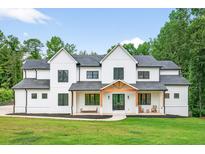 Beautiful two-story modern farmhouse with black-framed windows and professional landscaping at 3180 Lee Dr, Buford, GA 30518