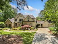 Charming two-story home with stone accents, three-car garage and well-manicured landscaping at 8170 Hurakan Creek Xing, Cumming, GA 30028