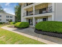 Charming condo building featuring manicured landscaping, walkways, and private patios at 1150 Collier Nw Rd # D20, Atlanta, GA 30318