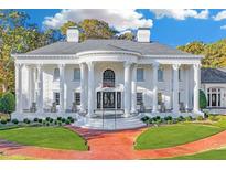 Stately white brick home with grand entrance featuring large columns and manicured landscaping at 1445 Hillside Dr, Grayson, GA 30017