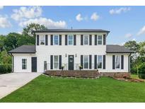 Charming two-story home with a well-manicured lawn and black shutters on the windows at 2284 Briarwood Cir, Conyers, GA 30094