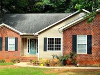 Charming brick home with a well-manicured lawn and inviting front entrance, featuring a beautiful teal door at 320 Orleans Blvd, Mcdonough, GA 30253