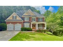 Charming two-story brick home featuring an attached two-car garage, covered porch and a well manicured lawn at 3744 Heathermoor Ct, Dacula, GA 30019