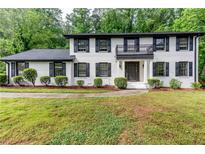 Charming two-story home featuring a painted brick facade, black shutters and balcony at 5380 Northchester Ct, Dunwoody, GA 30338