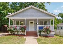 Charming bungalow features a covered front porch with rose bushes and a freshly painted exterior at 789 Third St, Stone Mountain, GA 30083
