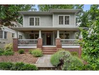 Charming two-story home featuring a welcoming front porch, brick accents, and manicured landscaping at 1066 High Point Ne Dr, Atlanta, GA 30306