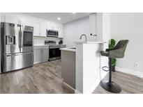 Modern kitchen features stainless steel appliances, gray cabinets, and breakfast bar with a stool at 2657 Lenox Ne Rd # A-5, Atlanta, GA 30324