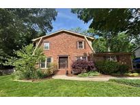 Charming brick home featuring a well-manicured lawn and mature trees, creating a welcoming curb appeal at 1652 Weymouth Ct, Tucker, GA 30084