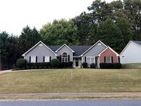 Charming single-story home featuring a well-manicured lawn, gray siding, and a welcoming front entrance at 2945 Dogwood Creek Parkway, Duluth, GA 30096