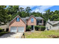 Charming brick two-story home with an attached two-car garage and a lush green lawn at 3881 Micah Ln, Ellenwood, GA 30294