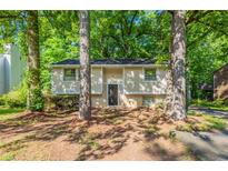 Charming home featuring a well-manicured front yard with mature trees providing shade at 5372 Martins Crossing Rd, Stone Mountain, GA 30088