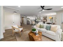 Open-concept living room featuring a white sofa, wood floors, and seamless flow to the modern kitchen at 638 Medford Se Pl, Smyrna, GA 30080