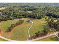 Expansive aerial view of a sprawling estate with a winding driveway and lush surrounding landscape at 829 Christopher Rd, Sharpsburg, GA 30277