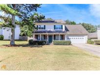Charming two-story home with a well-manicured front yard and a two-car garage, complemented by lush landscaping at 421 Old Ivy Path, Mcdonough, GA 30253