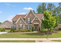Charming brick home features a manicured lawn, complemented by lush landscaping, and a welcoming front entrance at 1972 Clovercroft Rd, Acworth, GA 30101