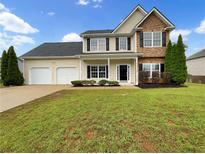 Charming two-story home featuring a manicured lawn and attached two-car garage at 617 Kyles Cir, Hiram, GA 30141
