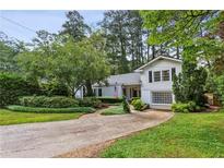 Inviting two-story home featuring manicured landscaping, a well-kept lawn, and a quaint front-facing garage at 88 Karland Nw Dr, Atlanta, GA 30305