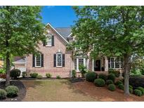 Charming two-story brick home with a well-manicured lawn and mature trees, offering great curb appeal at 2020 Windermere Xing, Cumming, GA 30041