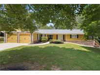 Charming ranch home with a well-manicured lawn, attached garage, and mature trees in a desirable neighborhood at 2460 Due West Nw Cir, Kennesaw, GA 30152