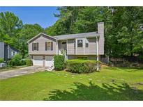 Charming split-level home with a well-maintained lawn, attached garage, and inviting curb appeal at 4035 Woodbridge Ct, Powder Springs, GA 30127