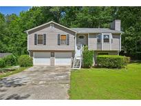 Charming two-story home with a well-manicured lawn and a two-car garage at 4035 Woodbridge Ct, Powder Springs, GA 30127