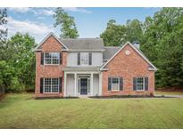 Charming two-story home featuring a combination of brick and siding, complemented by black shutters and a well-maintained lawn at 463 The Gables Dr, Mcdonough, GA 30253